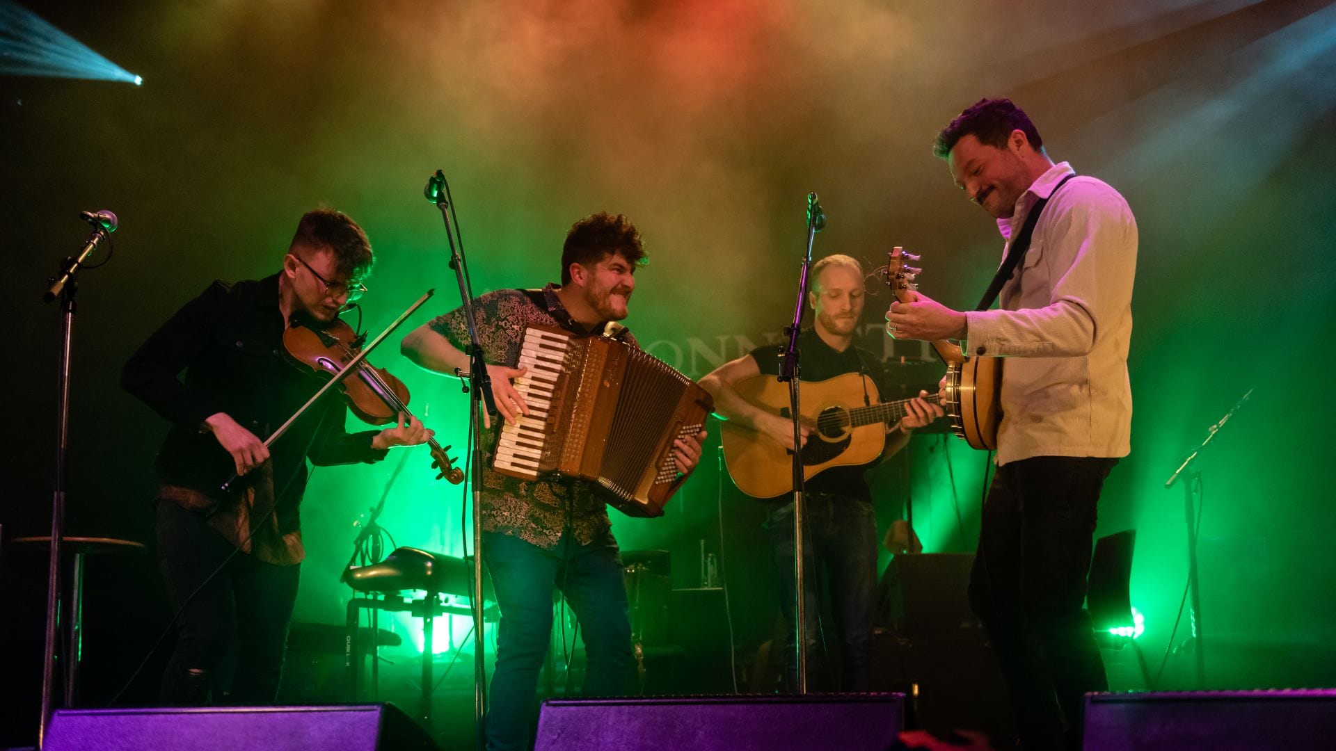 Four folk musicians on stage
